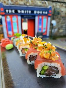 a row of sushi on a table with a train at The White House in Kinsale