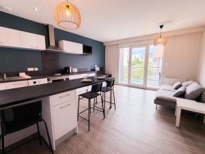a kitchen and living room with a table and a couch at Volcania Suites in Clermont-Ferrand