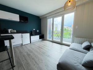 a living room with a bed and a large window at Volcania Suites in Clermont-Ferrand