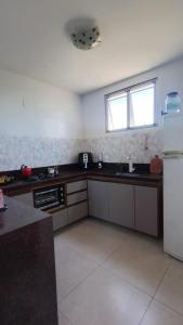 a kitchen with a sink and a refrigerator at Refúgio da praia in Serra