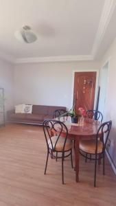 a dining room table with chairs and a couch in a room at Refúgio da praia in Serra