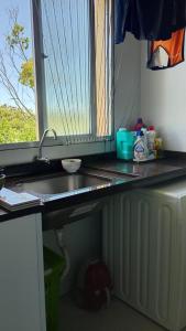 a kitchen counter with a sink and a window at Refúgio da praia in Serra +2 photos