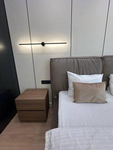 a bedroom with a bed and a wooden nightstand with a bed sidx sidx sidx at Euroconfort Ciocana Apartment Exfactor 6 in Chişinău