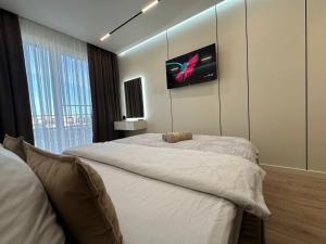 a bedroom with a large bed and a tv on the wall at Euroconfort Ciocana Apartment Exfactor 6 in Chişinău +23 photos