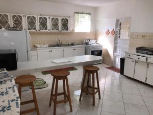 a kitchen with a counter and stools in it at Claraville Apartment - Unit 2 in Saint James