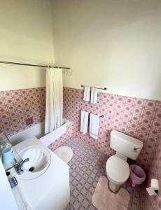 a bathroom with a white toilet and a sink at Claraville Apartment - Unit 2 in Saint James