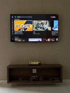 a flat screen tv hanging on a wall at The Grand Avora Apartment With 3 Ac And Free Parking in Lahore