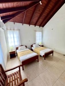 a bedroom with two beds and a wooden ceiling at Claraville Apartment - Unit 2 in Saint James