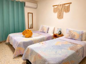 two beds in a room with blue curtains at Cocoa by Casa Momo Apartamento Acogedor y Céntrico in Bacalar