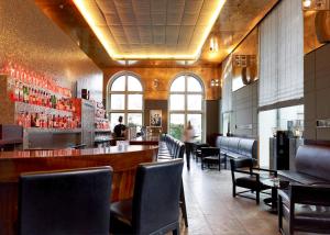 a bar in a restaurant with chairs and a counter at Sofitel Munich Bayerpost in Munich