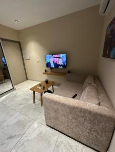 a living room with a couch and a flat screen tv at Regal View Residences & Suites in Cairo
