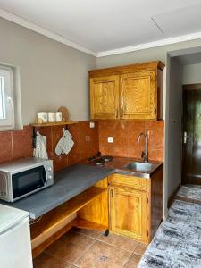 a kitchen with wooden cabinets and a microwave at Mont Peak Apartment in Kolašin