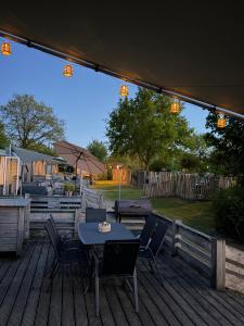 a patio with a table and chairs on a deck at Chalet Masion Meerwijck 6 aan het Zuidlaardermeer in Kropswolde