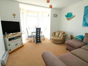 a living room with a couch and a flat screen tv at Ewyn Y Don in Holyhead