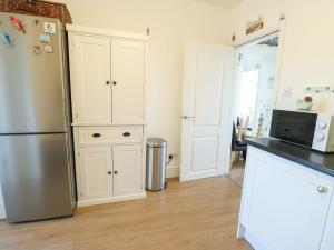 a kitchen with a refrigerator and a counter top at Ewyn Y Don in Holyhead +8 photos