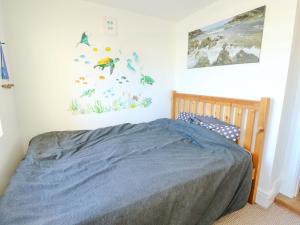 a bedroom with a bed with a blue comforter at Ewyn Y Don in Holyhead