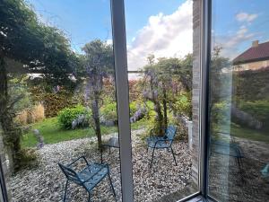 a view of a patio from a window with two chairs at De Groene Oase in Harkstede