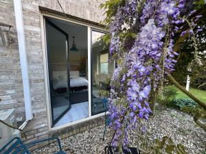 a wreath of purple flowers on the side of a house at De Groene Oase in Harkstede