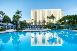 a large swimming pool with a large building in the background at MIAMI Collins Beach Apartments in Sunny Isles Beach