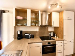 a kitchen with white appliances and wooden cabinets at Horner Viehweid in Schwangau