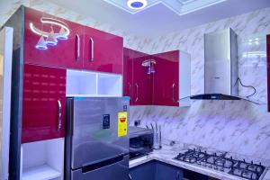 a kitchen with red cabinets and a stainless steel refrigerator at Eljay Luxury Stay in Ashalebotwe
