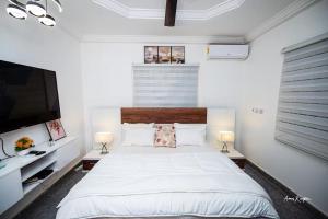 a bedroom with a large bed and a flat screen tv at Eljay Luxury Stay in Ashalebotwe