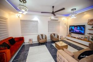 a living room with a red couch and a flat screen tv at Eljay Luxury Stay in Ashalebotwe