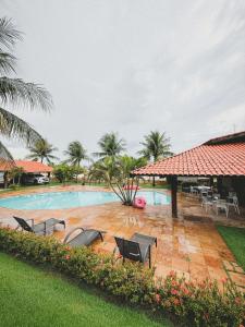 a swimming pool with a group of chairs in a yard at Casa Kite Academy in Caucaia