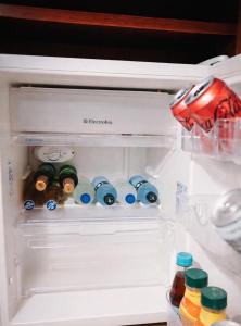 an open refrigerator filled with lots of drinks and bottles at Casa Kite Academy in Caucaia +9 photos