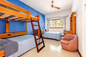 a bedroom with two bunk beds and a chair at Villa con piscina y acceso a laguna Yalku, Akumal in Akumal