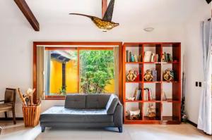 a living room with a couch and a book shelf at Villa con piscina y acceso a laguna Yalku, Akumal in Akumal