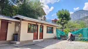 a small house with a fence in front of it at LVMR DORMS MOHAL Bhuntar in Shamshi