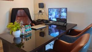 a office with a desk with a computer and chairs at LVMR DORMS MOHAL Bhuntar in Shamshi