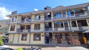 a large building with balconies on top of it at LVMR DORMS MOHAL Bhuntar in Shamshi +4 photos