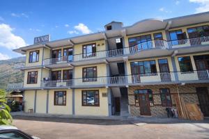 a building with balconies on top of it at LVMR DORMS MOHAL Bhuntar in Shamshi