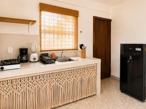 a kitchen with a sink and a black refrigerator at Cocoa by Casa Momo Apartamento Acogedor y Céntrico in Bacalar +18 photos