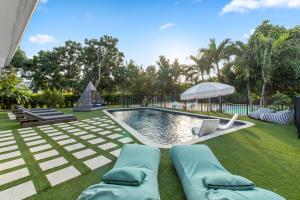 a swimming pool with two lounge chairs and an umbrella at Platinum Villa w Karaoke, Pickleball, BKB & Soccer in Davie