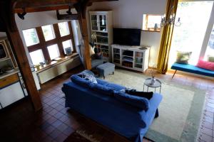 a living room with a blue couch and windows at Judies Garten in Füsing