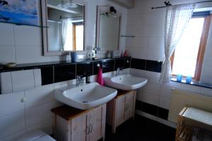 a bathroom with two sinks and a mirror at Judies Garten in Füsing +19 photos