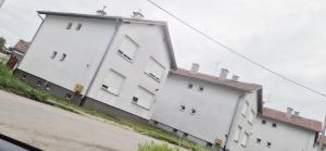 a large white building on the side of a street at Apartman Ivano in Vukovar