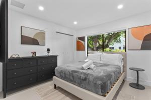 a bedroom with a bed and a dresser and a window at Platinum Villa w Karaoke, Pickleball, BKB & Soccer in Davie +82 photos