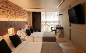 a hotel room with two beds and a flat screen tv at 5Q House Chapinero in Bogotá