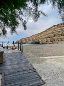 a wooden pathway to the beach with a hammock at Kritamos Beach House - Near the Beach with Easy Parking in Matala