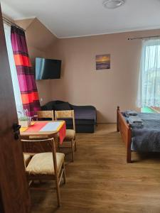 a room with a bed and a table and chairs at Duet in Władysławowo