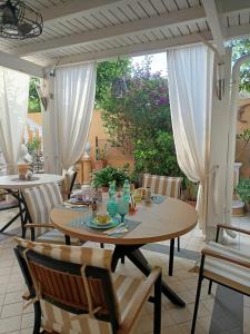 a wooden table and chairs on a patio at Domos Le Due Tuie in Piscinas +106 photos