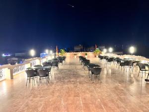 a row of tables and chairs on a patio at night at Maa Ambika Royal House in Baripāda