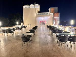 a row of tables and chairs on a patio at night at Maa Ambika Royal House in Baripāda
