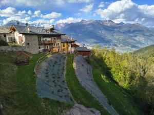 a house on a hill with mountains in the background at Chambres D'Hotes Les Fleurs in Pila