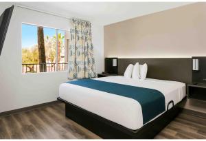 a hotel room with a large bed and a window at Studio 6 Tempe, AZ Elliot Road in Tempe