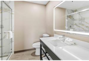 a bathroom with a sink and a toilet and a mirror at Studio 6 Tempe, AZ Elliot Road in Tempe